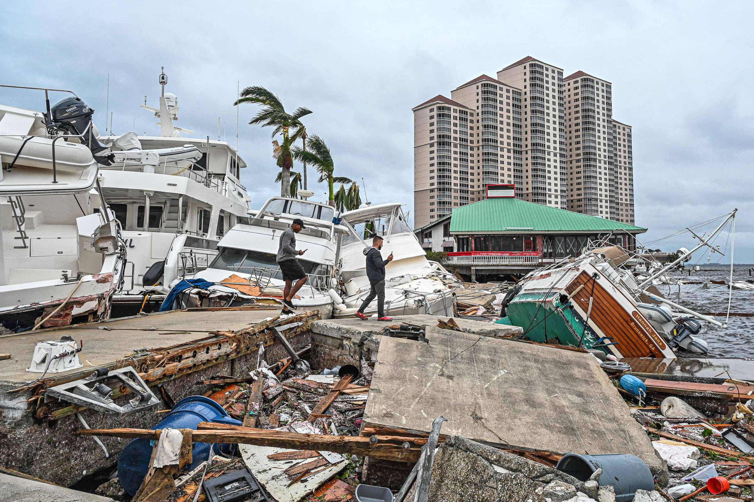 PHOTO: Residents inspect damage to a marina as boats are partially submerged in the aftermath of Hurricane Ian in Fort Myers, Fla., on Sept. 29, 2022.