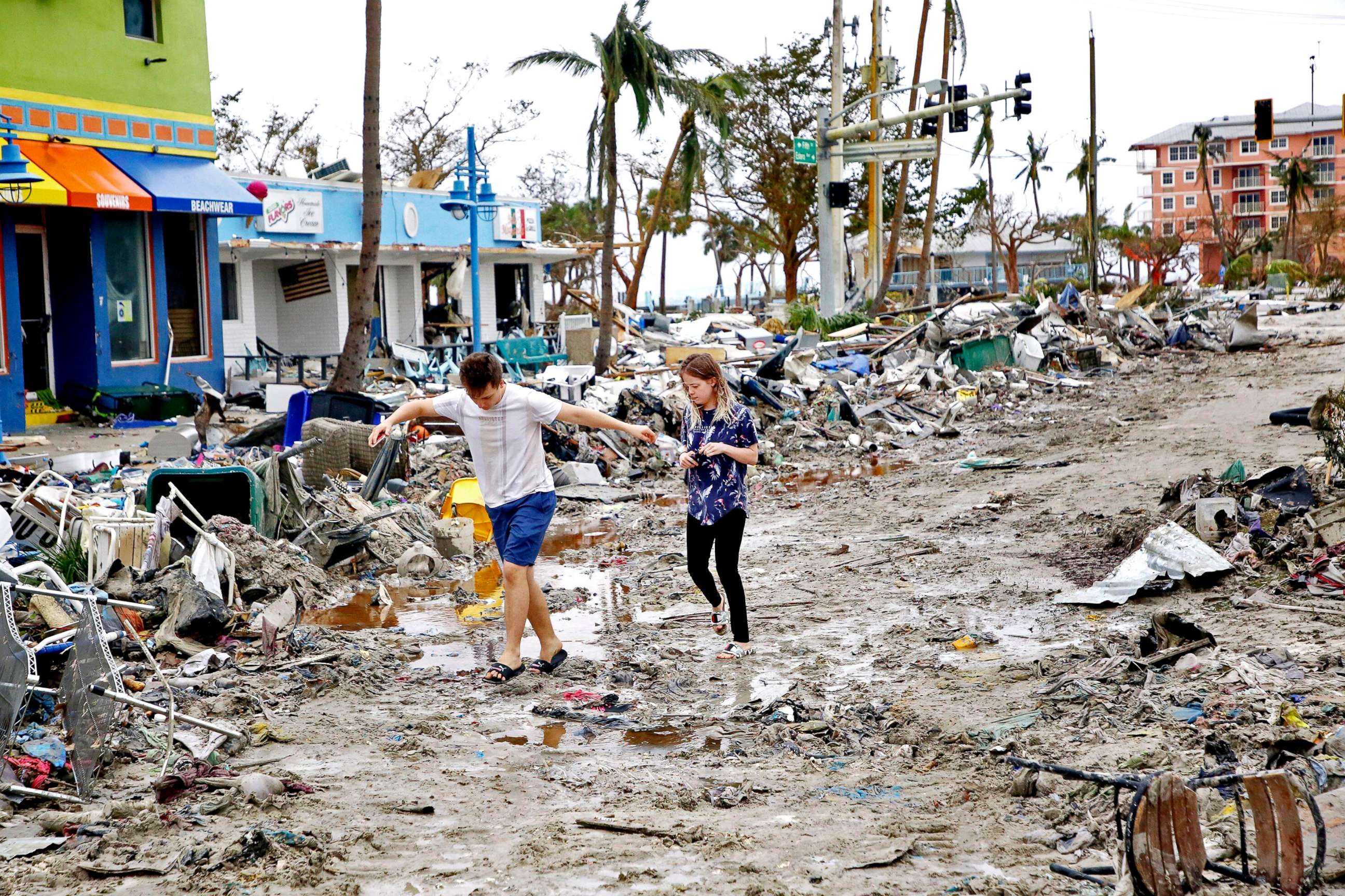 PHOTO: Jake Moses, 19, left, and Heather Jones, 18, of Fort Myers, explore a section of destroyed businesses at Fort Myers Beach, Fla., on Sep 29, 2022, following Hurricane Ian. 