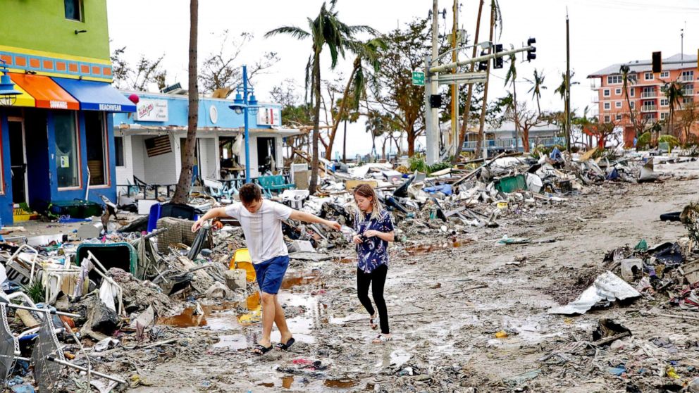 PHOTO: Jake Moses, 19, left, and Heather Jones, 18, of Fort Myers, explore a section of destroyed businesses at Fort Myers Beach, Fla., on Sep 29, 2022, following Hurricane Ian. 