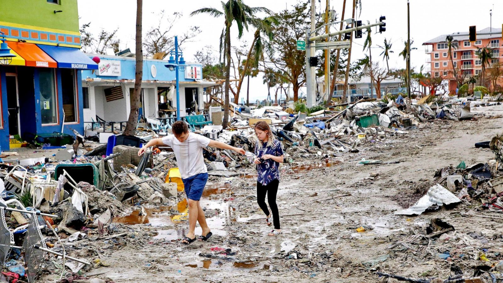 PHOTO: Jake Moses, 19, left, and Heather Jones, 18, of Fort Myers, explore a section of destroyed businesses at Fort Myers Beach, Fla., on Sep 29, 2022, following Hurricane Ian.