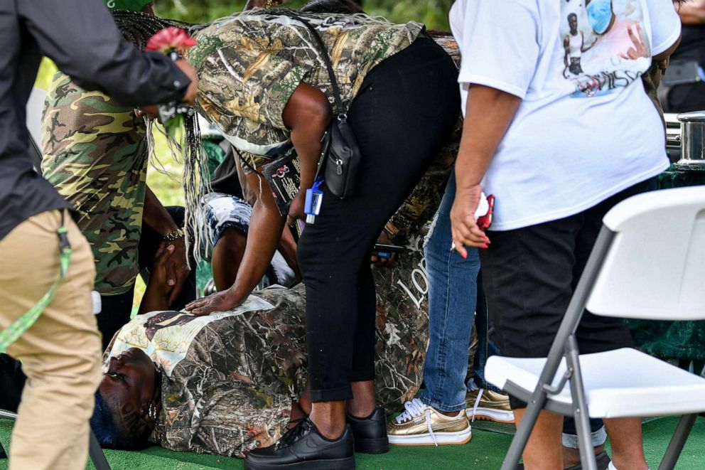 PHOTO: People assist the injured after a shot was fired during the interment of Sincere Pierce at Riverview Memorial Gardens on Nov. 28, 2020.