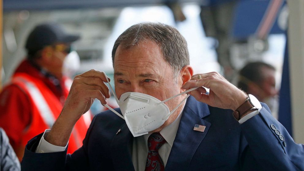 PHOTO: Utah Gov. Gary Herbert puts on a mask that came off a plane filled with personal protective equipment at the Delta Hanger, April 15, 2020, at the Salt Lake International Airport.
