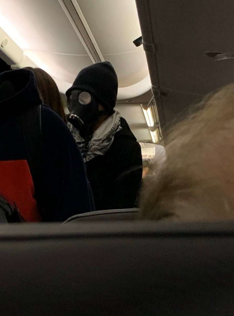 PHOTO: An unidentified man wearing a gas mask is seen aboard an American Airlines flight from Dallas to Houston, Jan. 30, 2020.