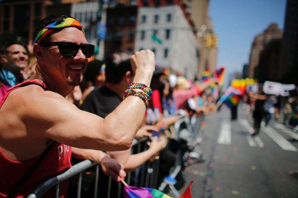 PHOTO: Revellers standing on Seventh Avenue watch the annual Pride Parade on June 24, 2018 in New York City.