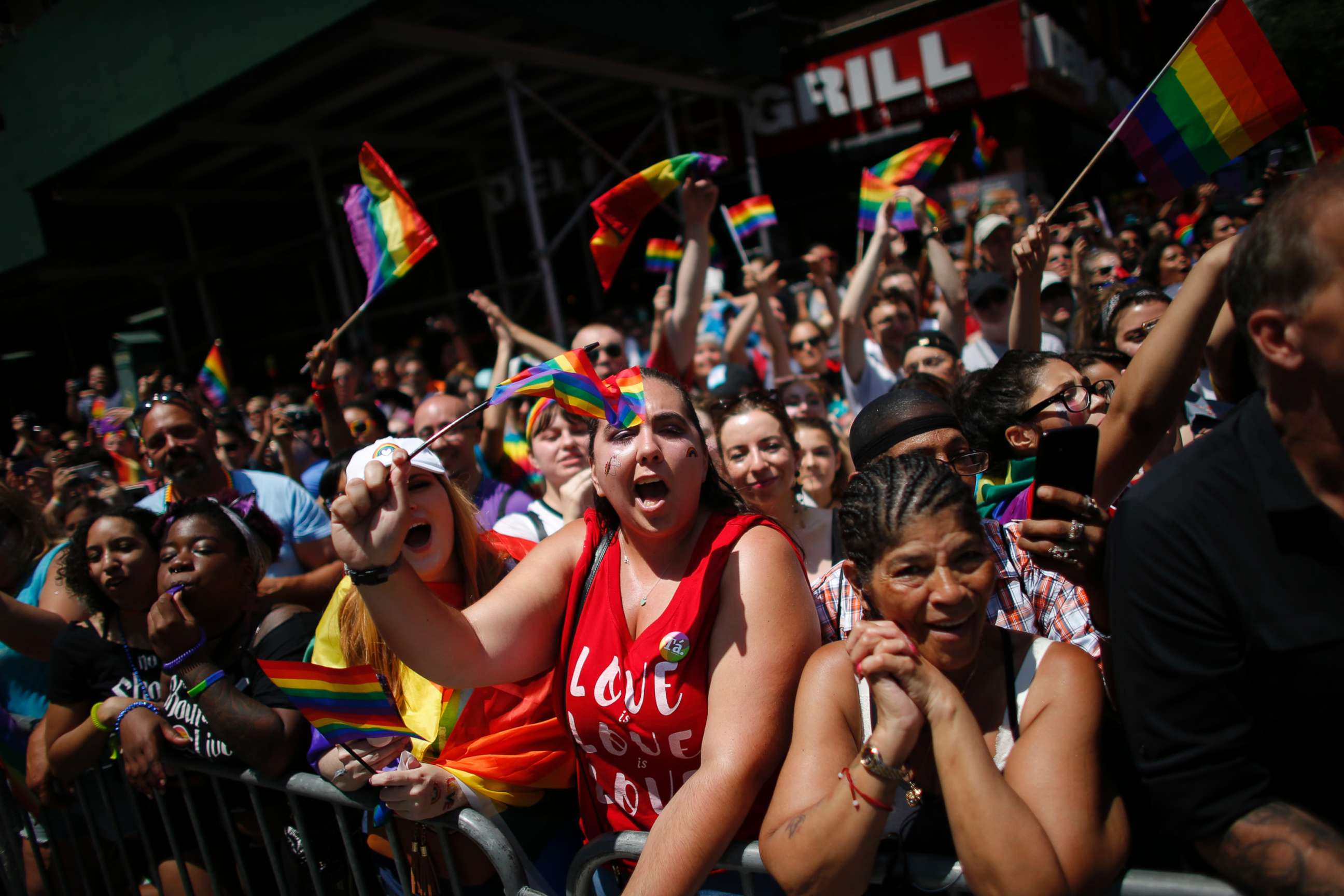 PHOTO: Revellers standing on Seventh Avenue watch the annual Pride Parade on June 24, 2018 in New York City.