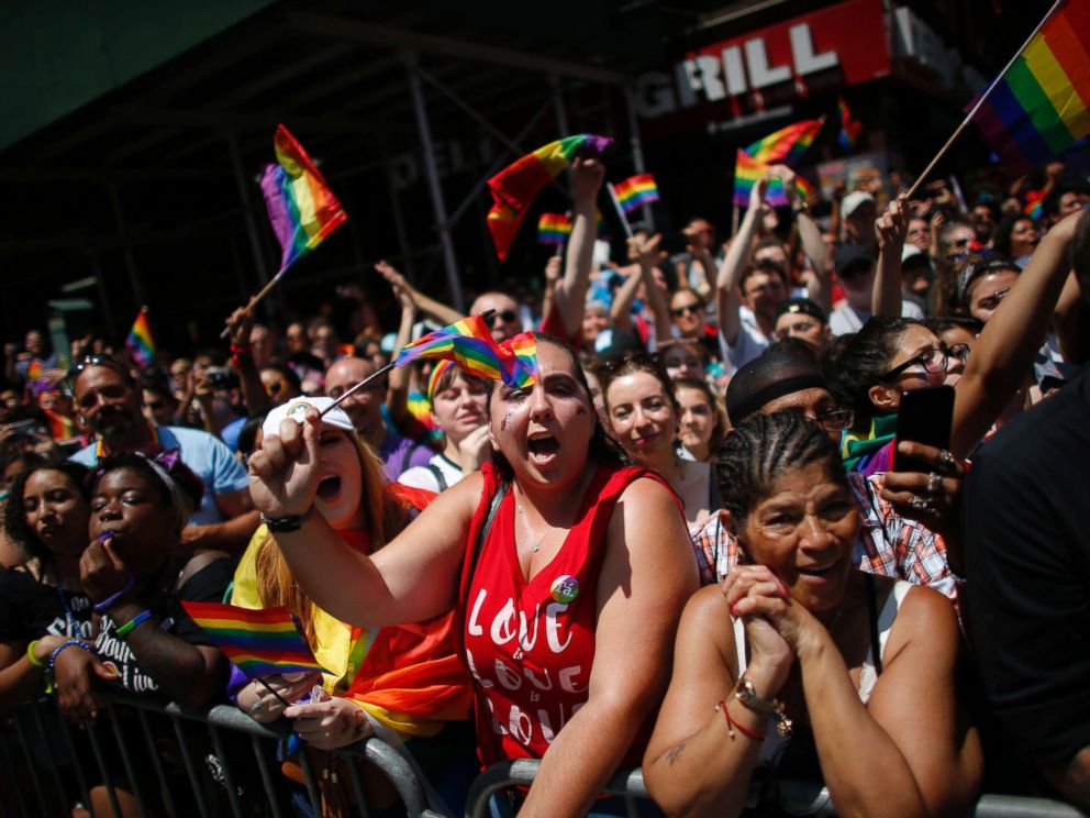 PHOTO: Revellers standing on Seventh Avenue watch the annual Pride Parade on June 24, 2018 in New York City.