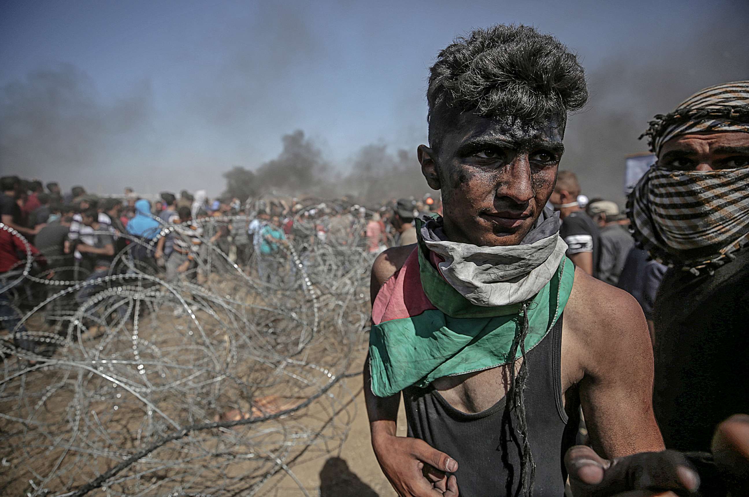 PHOTO: Palestinians protesters pull barbed wire fence installed by Israeli army along the border during clashes after protests near the border with Israel in the east of Gaza Strip, May 14, 2018.