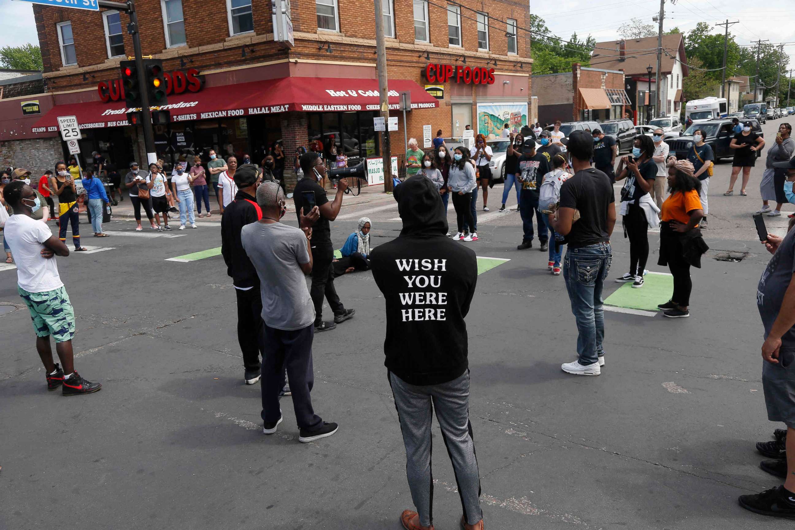 PHOTO: Protesters gather by a makeshift memorial, Wednesday, May 27, 2020, in Minneapolis, near the site where George Floyd, a black man who was taken into police custody on Monday and later died.