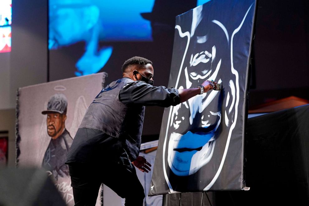 PHOTO: A man draws an image of George Floyd during the funeral service for Floyd at The Fountain of Praise Church on June 9, 2020, in Houston.