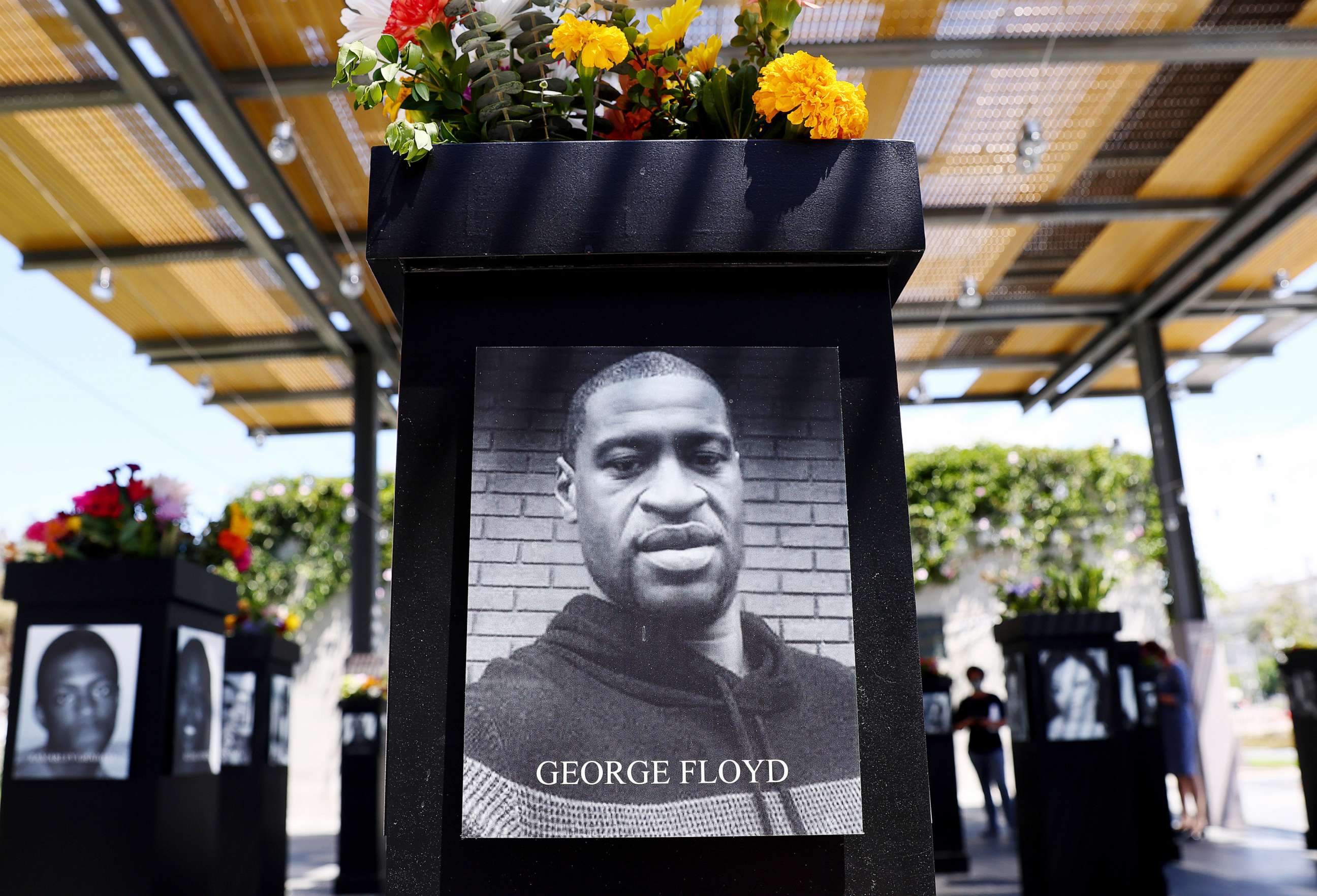 PHOTO: A photograph of George Floyd is displayed along with other photographs at the Say Their Names memorial exhibit at Martin Luther King Jr. Promenade, July 20, 2021, in San Diego, Calif.