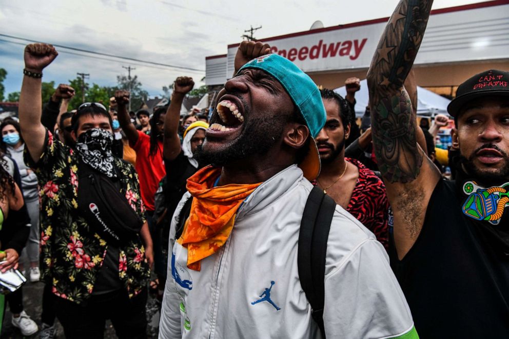 PHOTO: People raise their hands and kneel down as they protest at the makeshift memorial in honor of George Floyd, on June 2, 2020, in Minneapolis.