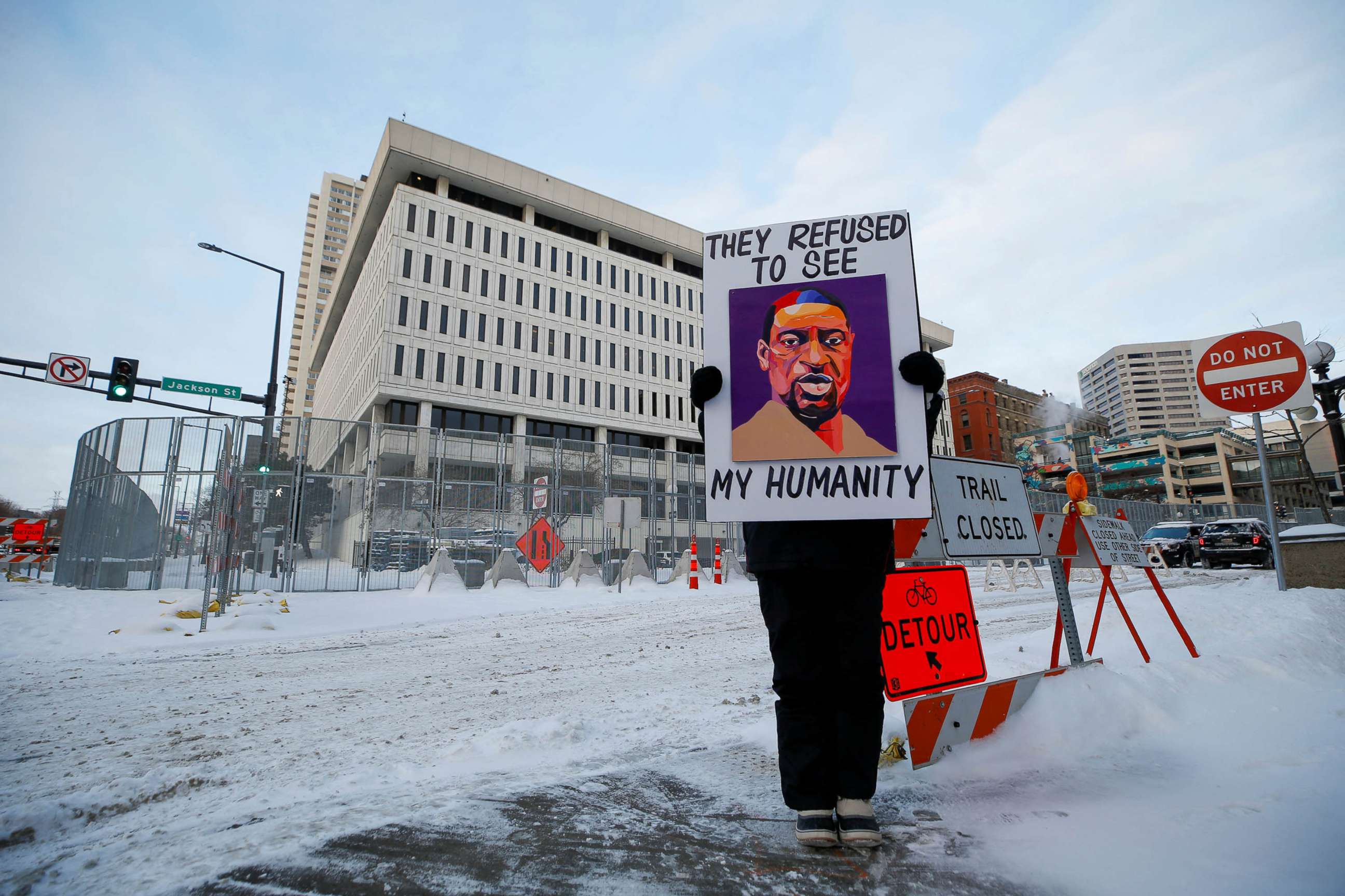 PHOTO: A protestor stands outside of the courthouse before opening arguments of the civil trial of three former police officers charged with violating George Floyd's civil rights when they took part in his deadly arrest in St. Paul, Minn., Jan. 24, 2022. 