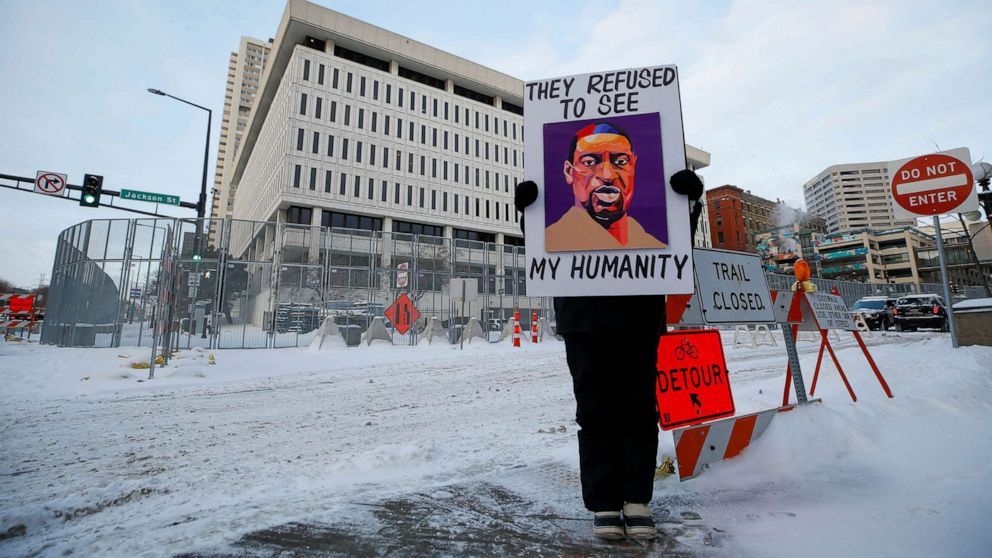 PHOTO: A protestor stands outside of the courthouse before opening arguments of the civil trial of three former police officers charged with violating George Floyd's civil rights when they took part in his deadly arrest in St. Paul, Minn., Jan. 24, 2022. 