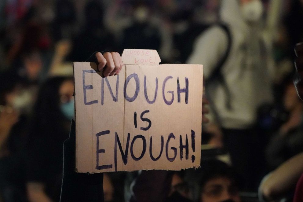 PHOTO: A person holds up a sign as protesters kneel on Canal Street in New York on May 31, 2020, during a demonstration over the death of George Floyd in police custody in Minneapolis.