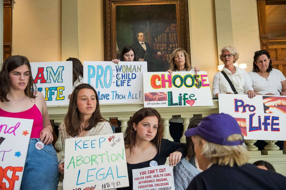 PHOTO: Abortion rights supporters and anti-abortion demonstrators display their signs in the lobby of the Georgia State Capitol building at the Georgia State Capitol building in Atlanta, March 22, 2019.