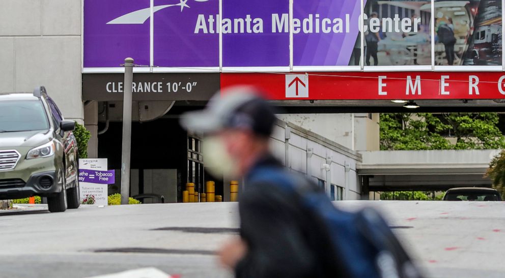 PHOTO: A masked man passes Wellstar Atlanta Medical Center on Boulevard in Atlanta, May 20, 2020.