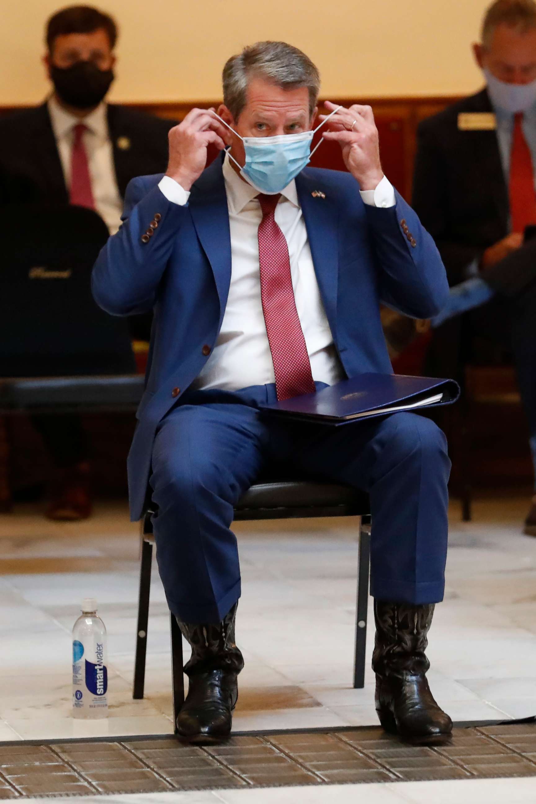 PHOTO: Georgia Gov. Brian Kemp adjusts his face covering as the waits to speak during a coronavirus briefing at the Capitol, July 17, 2020, in Atlanta.