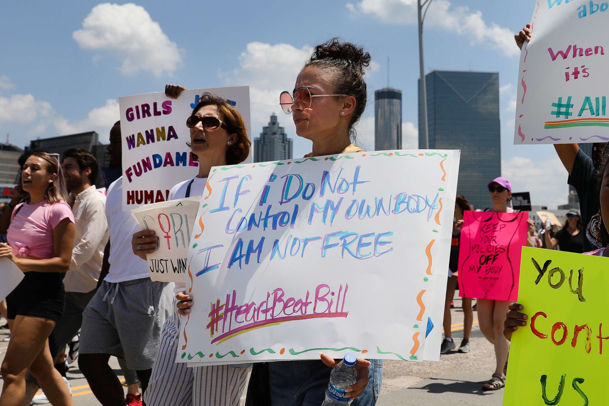 PHOTO: Demonstrators hold signs while marching during a protest against Georgia's 'heartbeat' abortion bill in Atlanta, Georgia, May 25, 2019. The bill bans abortion after a doctor can detect a fetal heartbeat, usually around the sixth week of pregnancy.