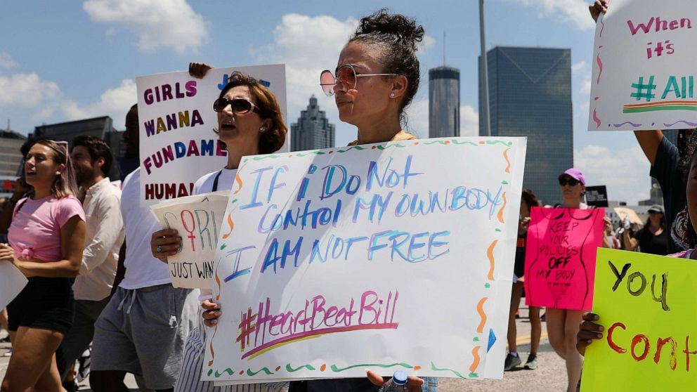 PHOTO: Demonstrators hold signs while marching during a protest against Georgia's 'heartbeat' abortion bill in Atlanta, Georgia, May 25, 2019. The bill bans abortion after a doctor can detect a fetal heartbeat, usually around the sixth week of pregnancy.