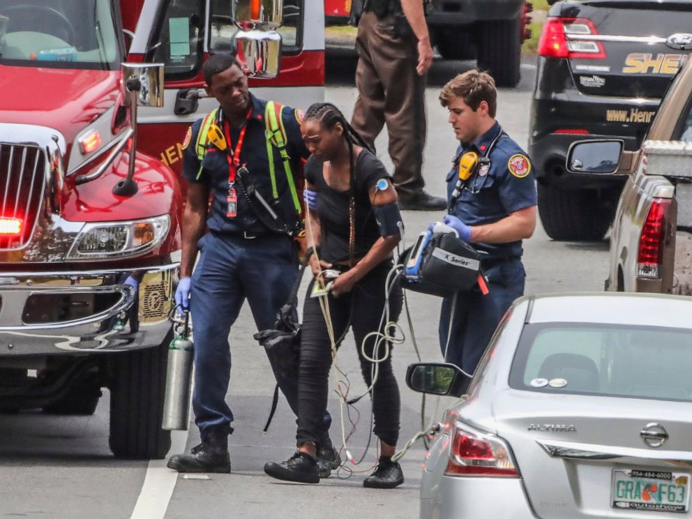 PHOTO: Henry County paramedics examine a woman near a scene after a gunman reportedly shot a few Henry County police officers in Stockbridge, Ga., Thursday, April 4, 2019.