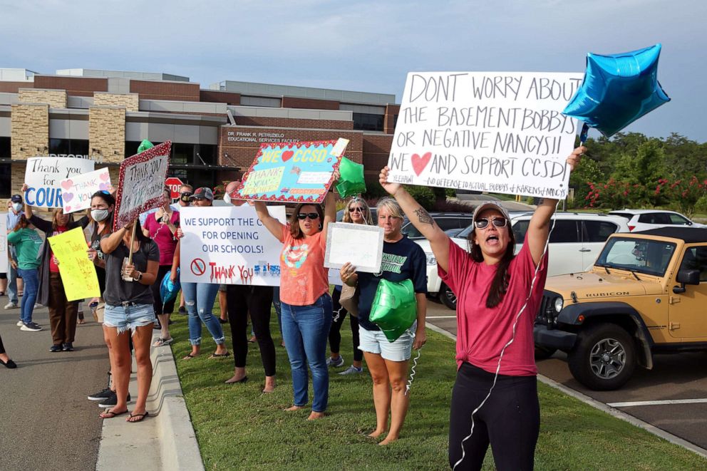 PHOTO: Supporters of the Cherokee County School District's decision to reopen schools to students during the coronavirus pandemic rally outside the district's headquarters in Canton, Ga., Aug. 11, 2020.