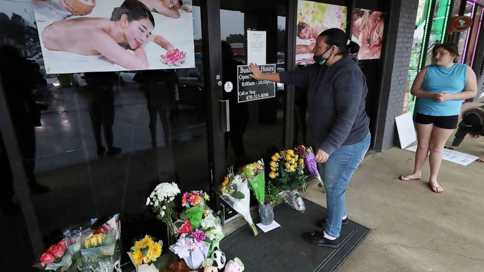 PHOTO: Jessica Lang pauses and places her hand on the door in a moment of grief after dropping off flowers with her daughter at Young' Asian Massage where four people were killed in Acworth, Ga., March 17, 2021.