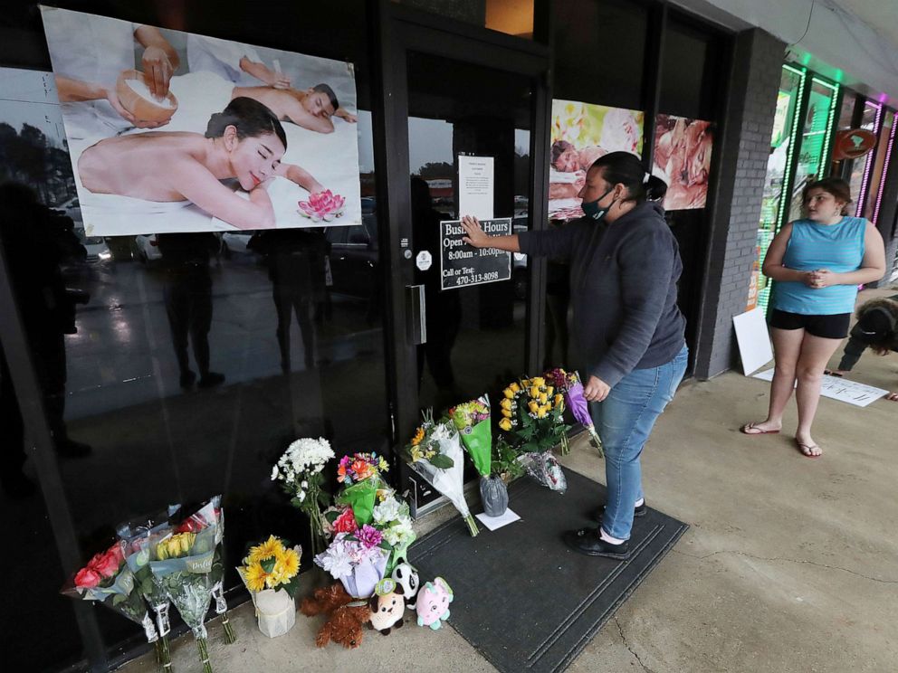 PHOTO: Jessica Lang pauses and places her hand on the door in a moment of grief after dropping off flowers with her daughter at Young' Asian Massage where four people were killed in Acworth, Ga., March 17, 2021.