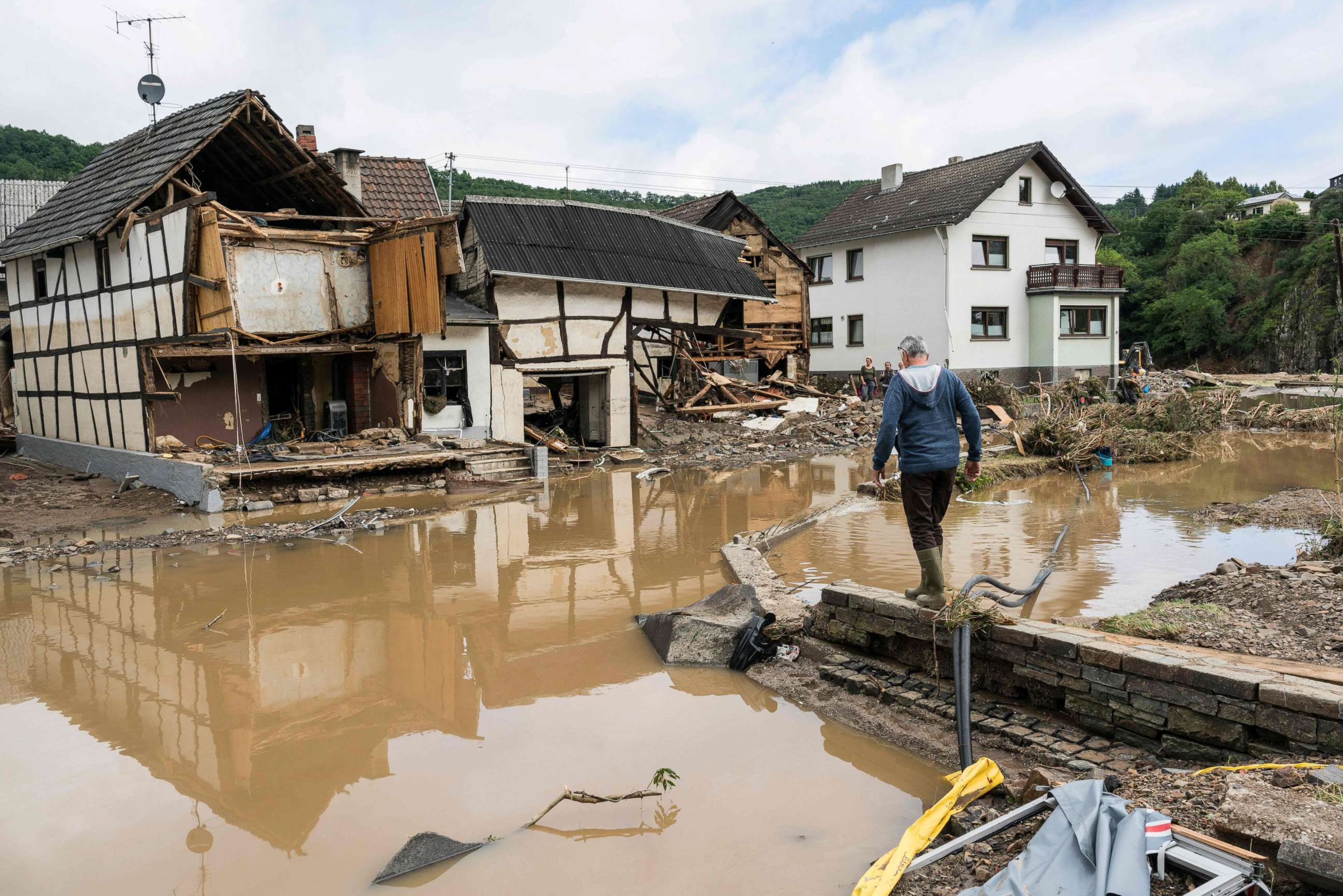PHOTO: A man walks through floodwater towards destroyed houses in Schuld near Bad Neuenahr, western Germany, on July 15, 2021.