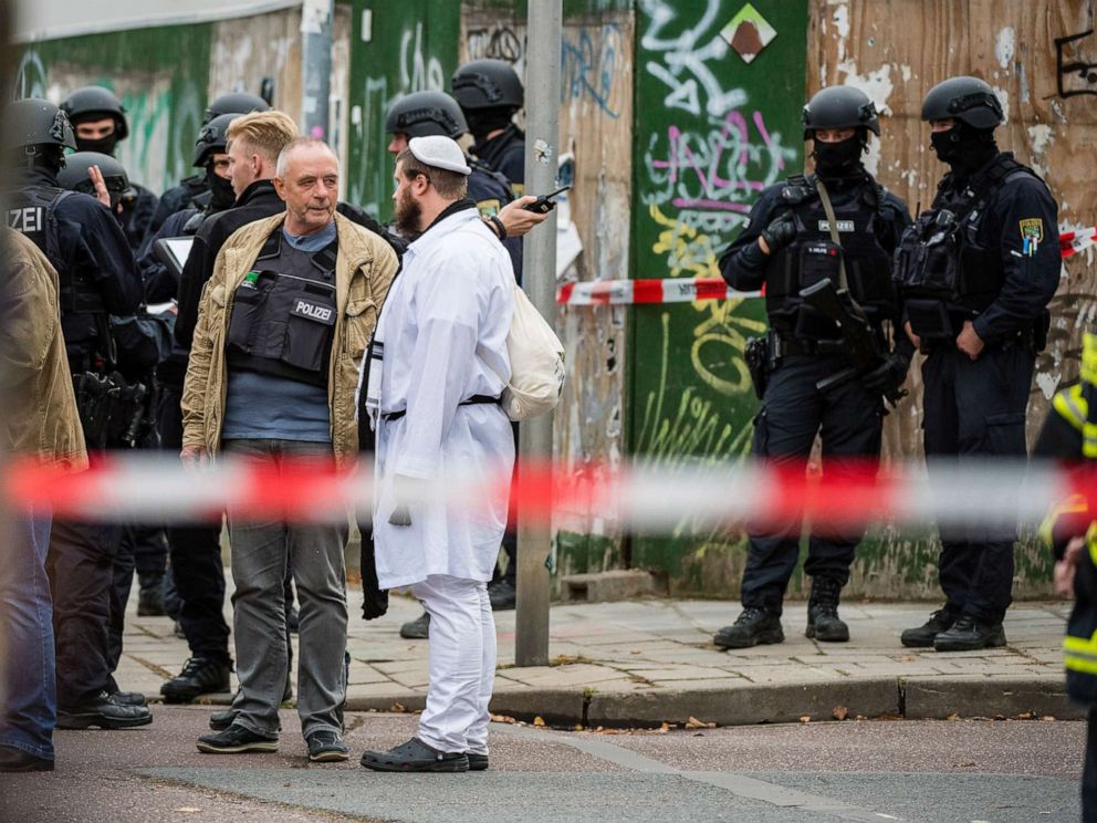 PHOTO: Rescued parishioners of the Jewish community and police forces stand near the scene of a shooting that has left two people dead on Oct. 9, 2019 in Halle, Germany.