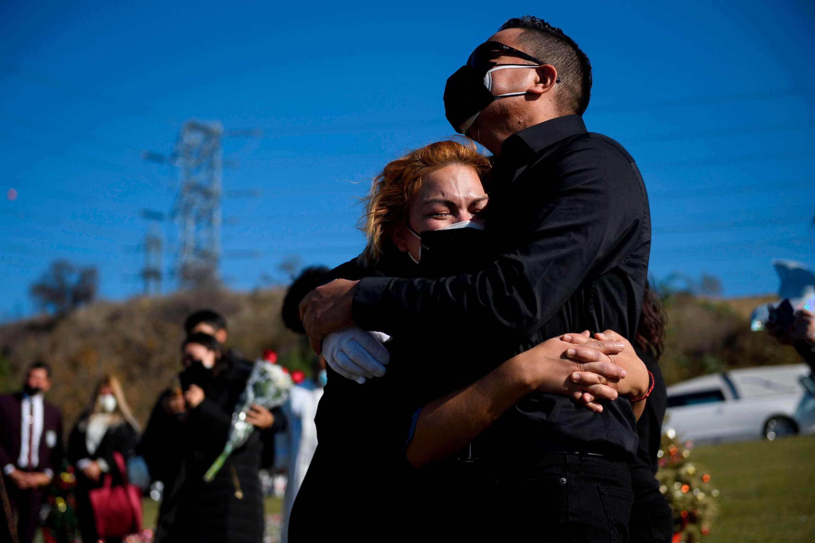 PHOTO: Maricela Arreguin Mejiam and her brother Nestor Arreguin mourn the death of their father Gilberto Arreguin Camacho, 58, due to Covid-19 during his burial at a cemetery on New Year's Eve, Dec. 31, 2020, in Whittier, Calif.