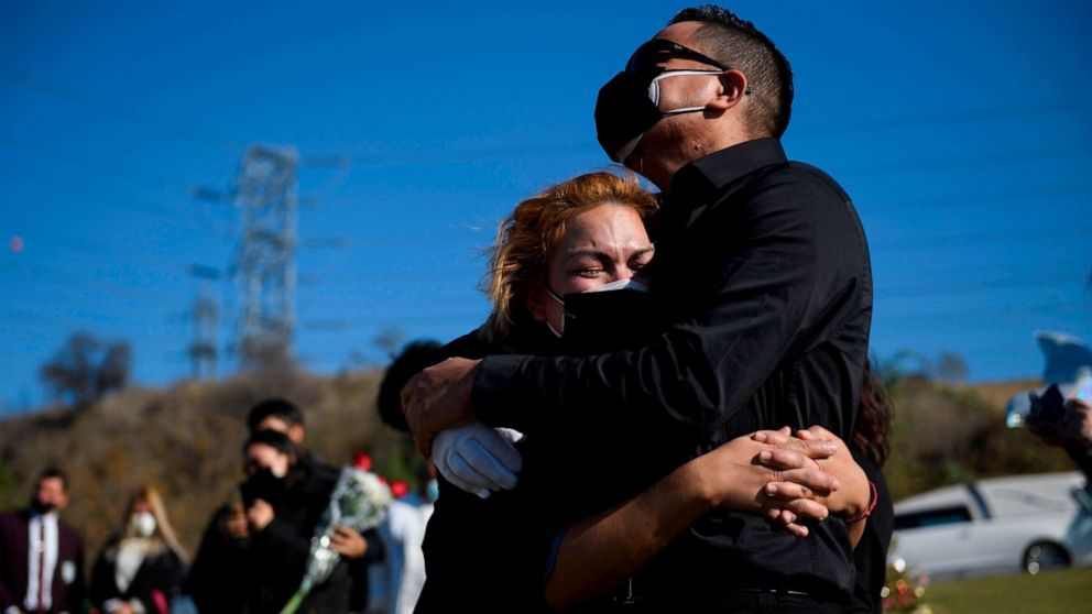 PHOTO: Maricela Arreguin Mejiam and her brother Nestor Arreguin mourn the death of their father Gilberto Arreguin Camacho, 58, due to Covid-19 during his burial at a cemetery on New Year's Eve, Dec. 31, 2020, in Whittier, Calif.