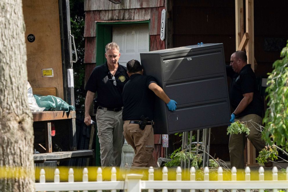 PHOTO: New York State police officers move a metal cabinet as law enforcement searches the home of Rex Heuermann, July 15, 2023, in Massapequa Park, N.Y.