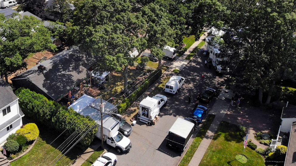 PHOTO: Authorities work at the home of suspect Rex Heuermann, left, in Massapequa Park, N.Y., July 24, 2023.