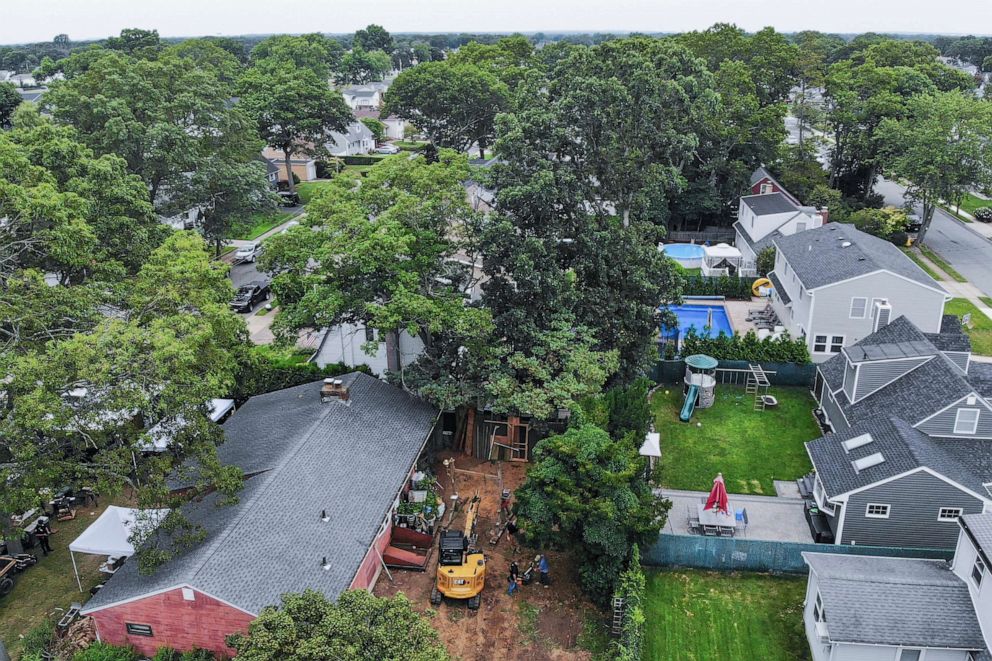 PHOTO: Authorities continue to work at the home of suspect Rex Heuermann, bottom left, with heavy equipment in the backyard, July 24, 2023, in Massapequa Park, N.Y.