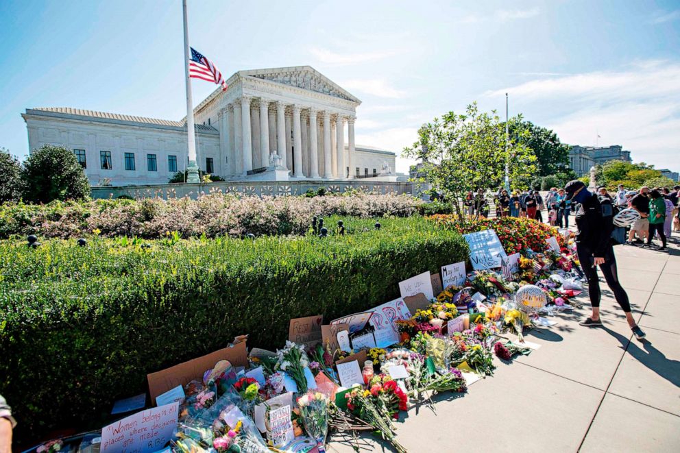 PHOTO: People place flowers outside of the Supreme Court in memory of Associate Justice Ruth Bader Ginsburg, in Washington, on Sept. 19, 2020.