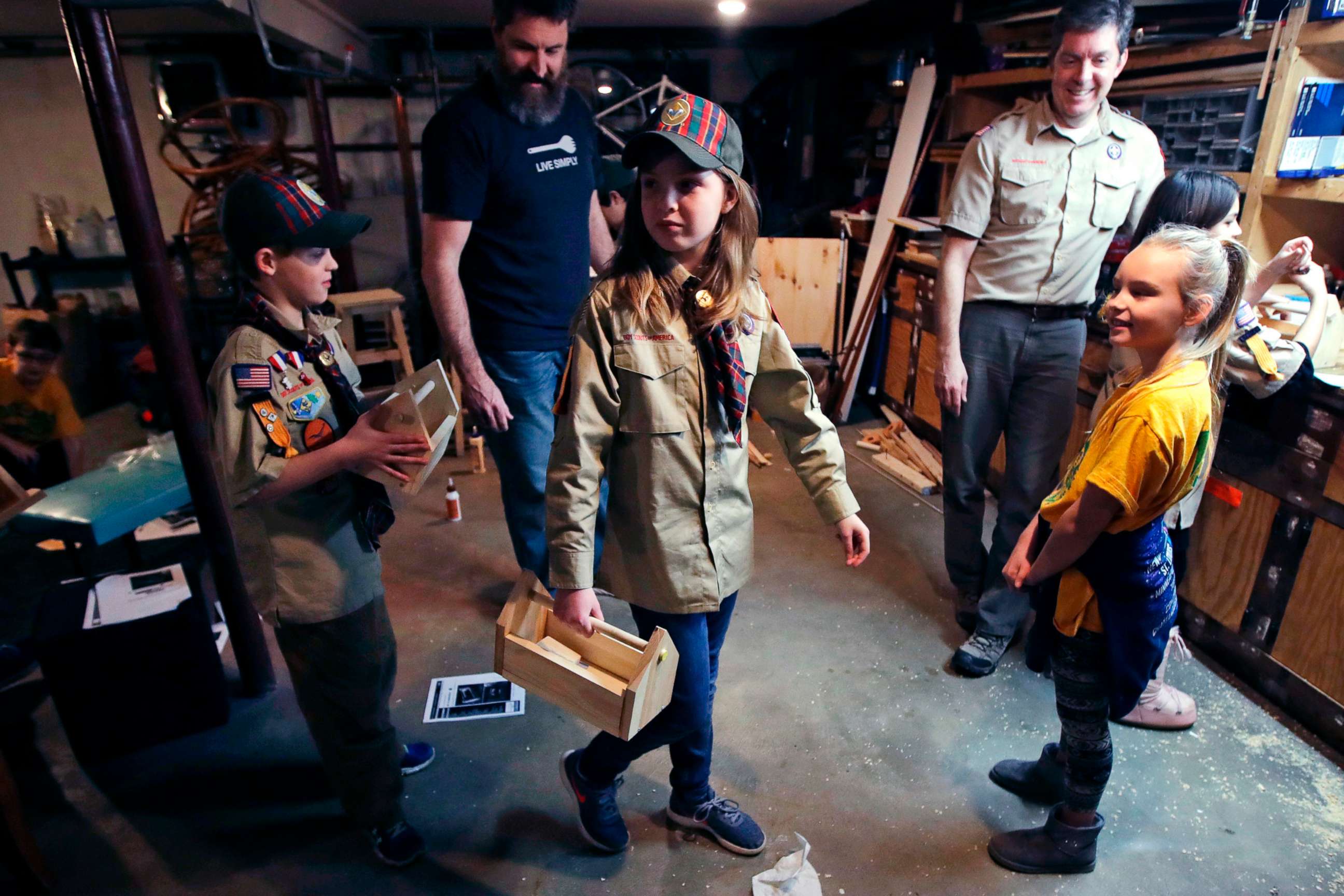 PHOTO: Tatum Weir, center, carries a tool box she built as her twin brother Ian, left, follows after a Cub Scout meeting in Madbury, N.H., March 1, 2018.