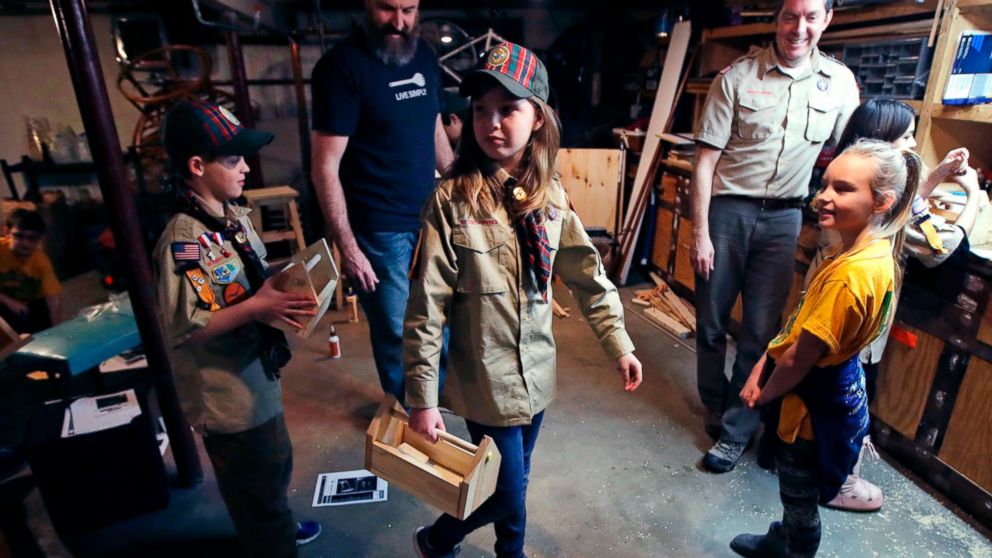 PHOTO: Tatum Weir, center, carries a tool box she built as her twin brother Ian, left, follows after a Cub Scout meeting in Madbury, N.H., March 1, 2018.