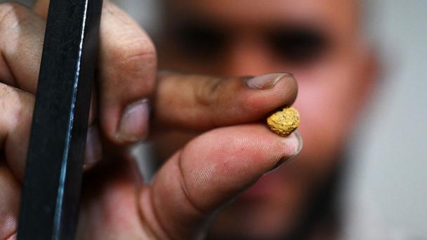 A man shows a gold nugget at a gold trading house in El Bagre municipality, Antioquia department, Colombia on March 23, 2023.