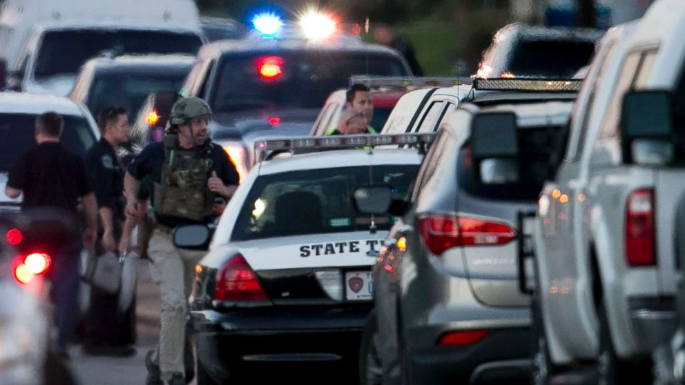 A law enforcement officer runs on Brodie Lane in Austin, Texas, moments after an explosion, March 20, 2018. Emergency teams were responding Tuesday night to another reported explosion in Texas' capital, this one at a Goodwill store in the southern part of the city.