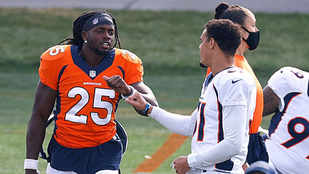 PHOTO: Denver Broncos running back Melvin Gordon, left, greets safety Justin Simmons as they take part in drills during an NFL football practice, Aug. 28, 2020, in Englewood, Colo. 