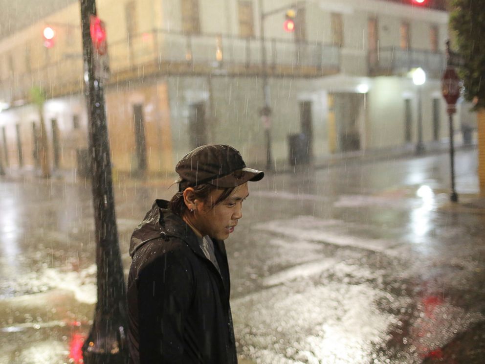 Charles Phanthapannha stands in the rain outside a bar as Tropical Storm Gordon approaches on Tuesday, Sept. 4, 2018 in Mobile, Ala.