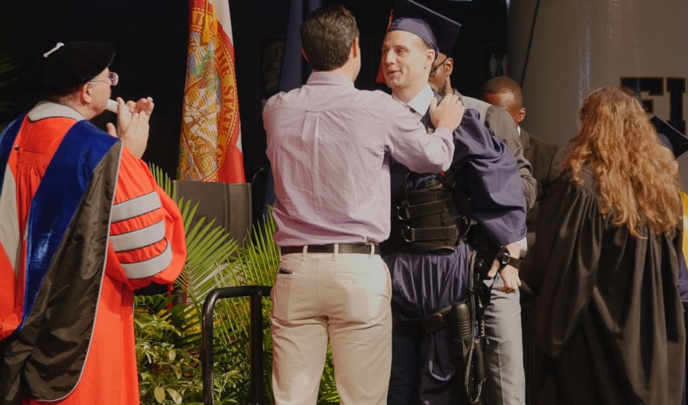 PHOTO: Aldo Amenta used an exoskeleton to walk across the stage to get his diploma at Florida International University. 