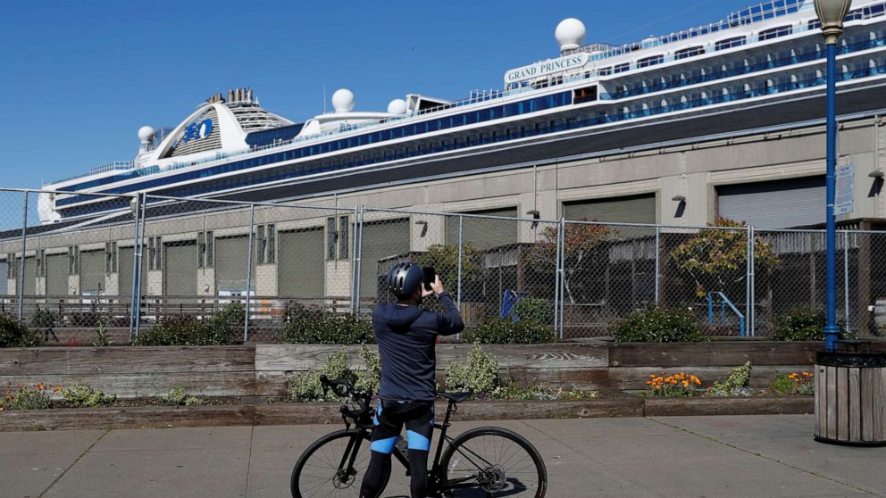 PHOTO: A cyclist takes a photograph of the Grand Princess cruise ship docked at Pier 35 as the spread of COVID-19 continues in San Francisco on April 7, 2020.