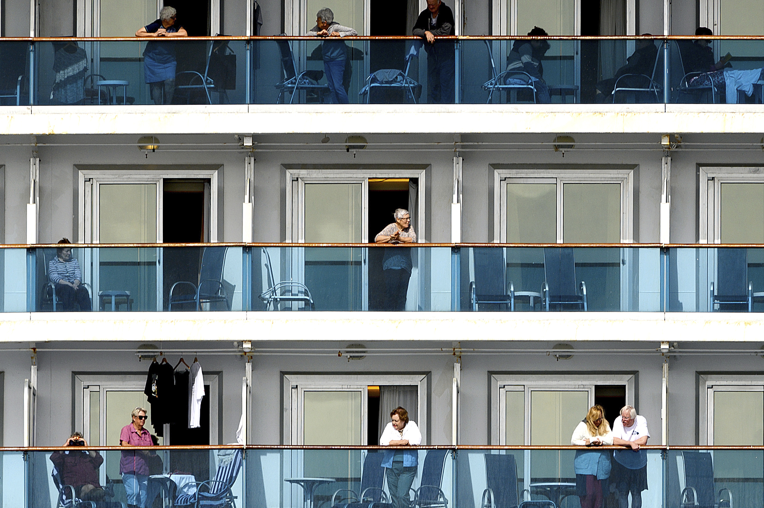 PHOTO: Passengers look out from balconies aboard the Grand Princess cruise ship as it maintains a holding pattern about 25 miles off the coast of San Francisco, California, on March 8, 2020.