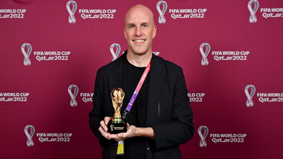 PHOTO: Grant Wahl smiles as he holds a World Cup replica trophy during an award ceremony in Doha, Qatar, on Nov. 29, 2022.