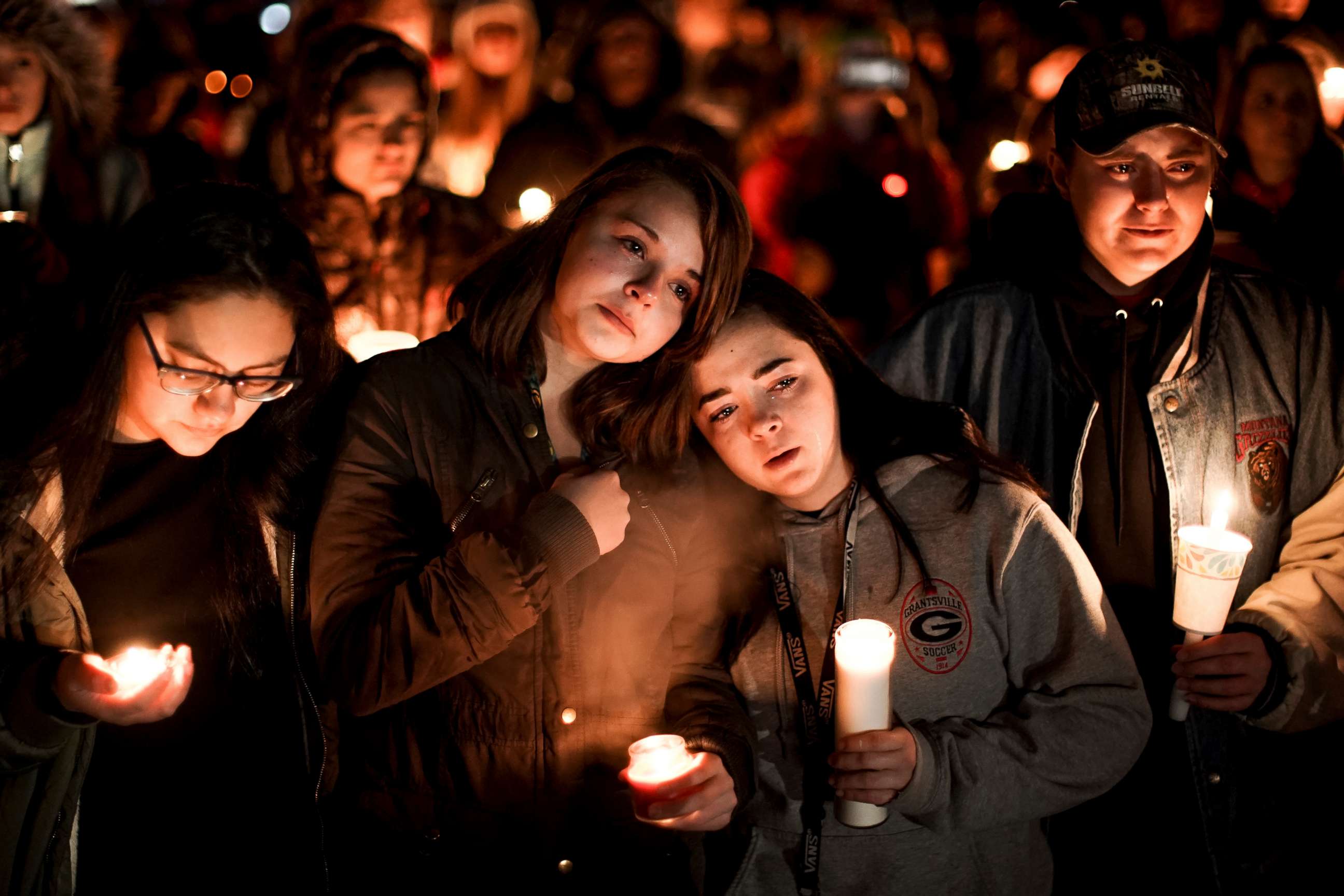 PHOTO: High School girls stand together at a candlelight vigil for the Haynie family at City Park in Grantsville, Utah, Jan. 20, 2020.