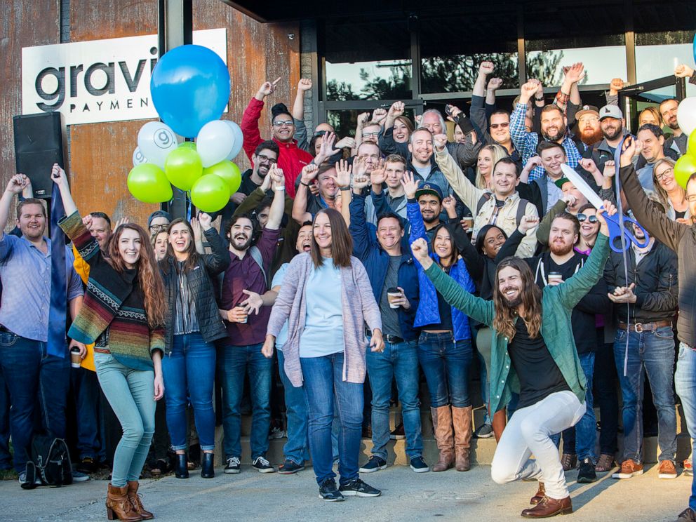 PHOTO: Dan Price, in the green shirt, CEO of Gravity Payments, celebrates the opening of Gravity Payments new Boise office. Price said he expects to add more workers over time. (Katherine Jones/Idaho Statesman/Tribune News Service via Getty Images)