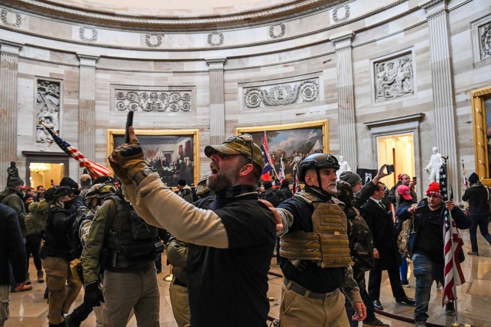 Supporters of President Donald Trump, including Army and Navy reserve veteran and Oath Keeper member (center right with helmet)Graydon Young, enter the US Capitol's Rotunda on Jan. 6, 2021, in Washington.
