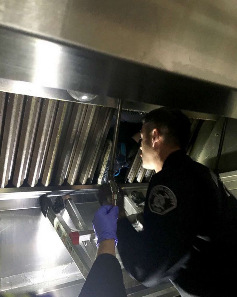 PHOTO: Firefighters work to free a suspected burglary who was stuck in a grease vent of a restaurant in San Lorenzo, Calif., Dec. 12, 2018.