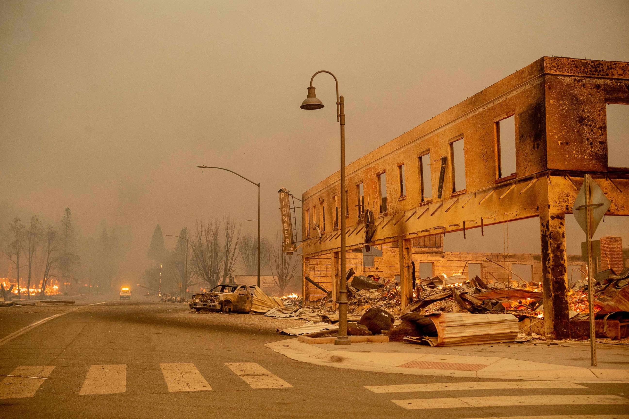 PHOTO: A firefighter saves an American flag as flames consume a home during the Dixie fire in Greenville, Calif., Aug. 4, 2021.